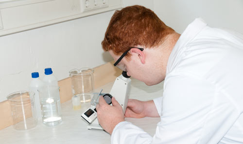 Laborant bei der Arbeit mit dem Abbe-Refraktometer