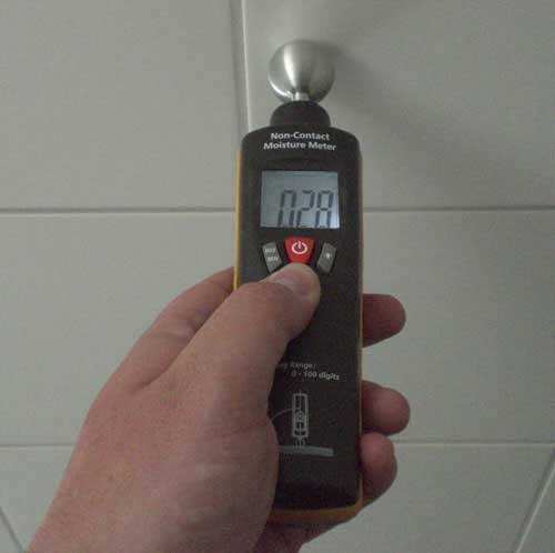 Das Materialfeuchte-Messgerät bei der Messung einer Wand mit Fliesen