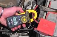 Elektrische Messtechnik: Stromzange bei der Prüfung einer Autobatterie.