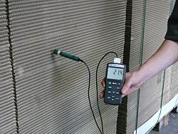 Das Laborthermometer PCE-T317 bei der Temperaturüberprüfung in einem Papierstapel