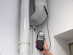 Das Laborthermometer PCE-T317 bei der Temperaturüberprüfung in einem Abluftkanal