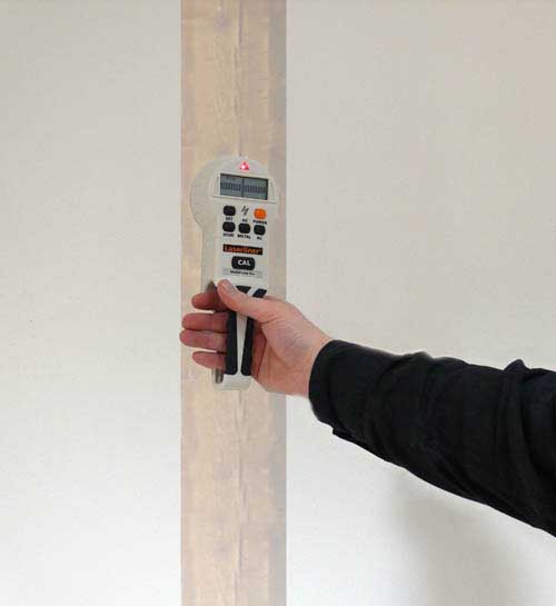 Ortungsgerät im Einsatz bei der Suche von  Holzbalken in der Wand.